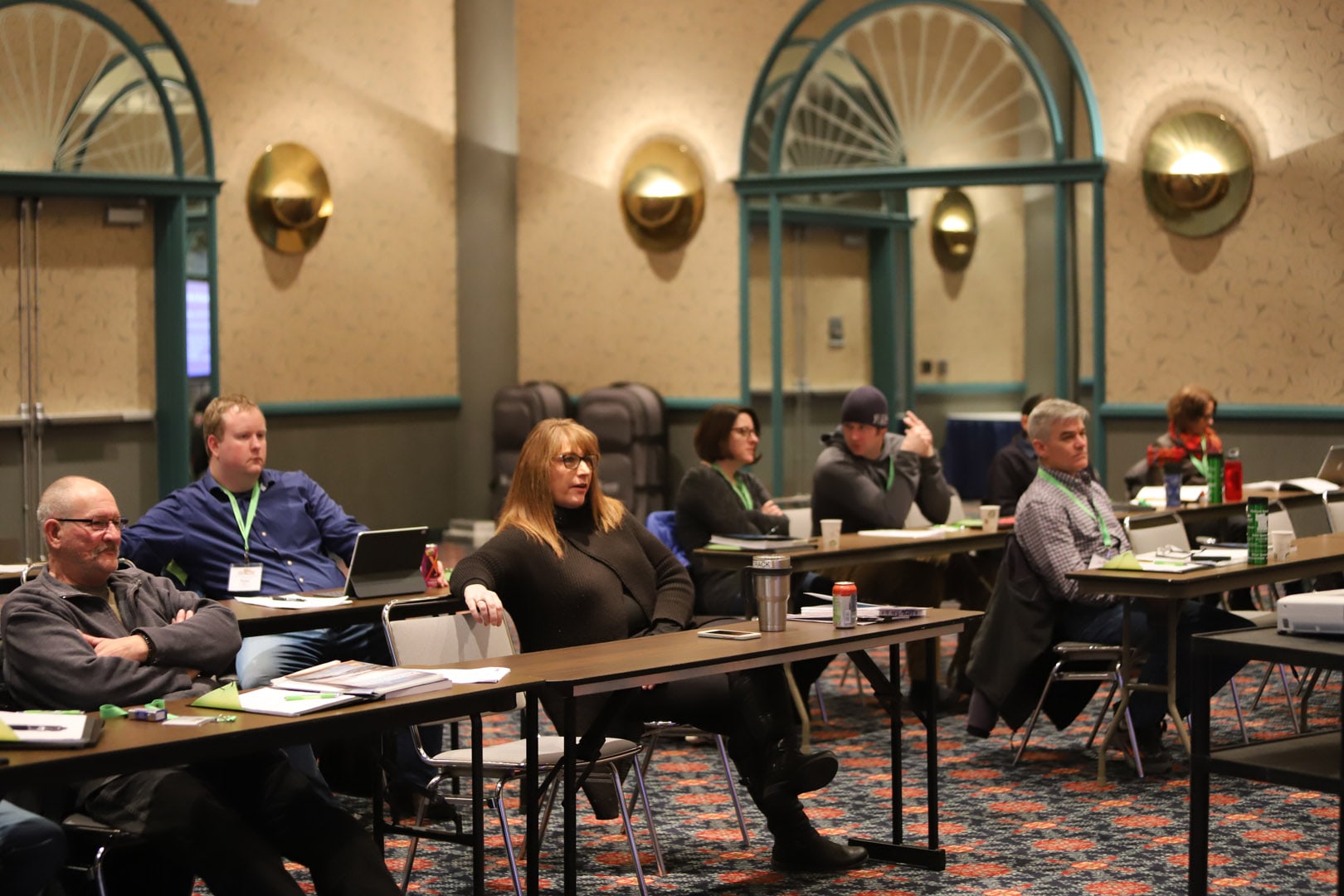 People at the conference sitting at tables listening to speakers.